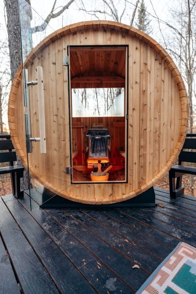 Compact pod-style sauna with a glass door on a garden deck